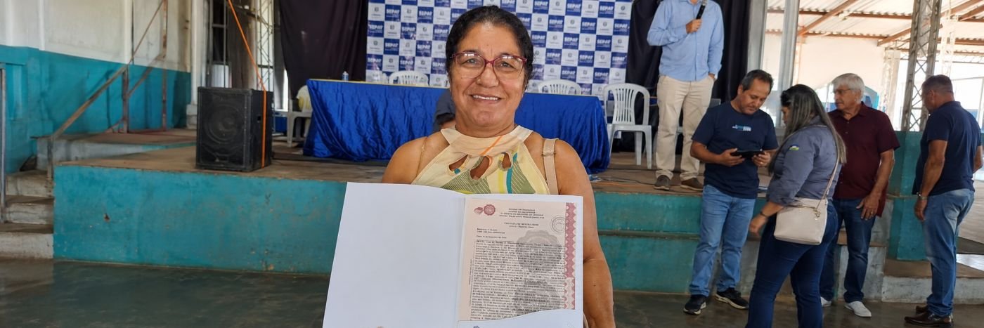 Moradora exibe certidão durante ação de regularização fundiária em Cacaulândia