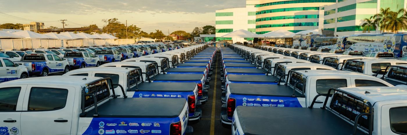 Frota de veículos organizada em fileiras durante entrega para reforçar o atendimento socioassistencial em Rondônia.