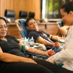 MPRO mobiliza doadores em campanha de sangue durante o Junho Vermelho Profissional de saúde acompanha doadora durante campanha de doação de sangue MPRO em ambiente institucional organizado.