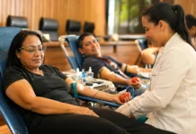 MPRO mobiliza doadores em campanha de sangue durante o Junho Vermelho Profissional de saúde acompanha doadora durante campanha de doação de sangue MPRO em ambiente institucional organizado.