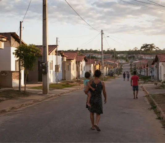 Cacoal abre inscrições para o Minha Casa, Minha Vida de 29 de junho a 15 de julho Rua com casas populares organizadas e família caminhando, representando inscrições para o Minha Casa Minha Vida em Cacoal.