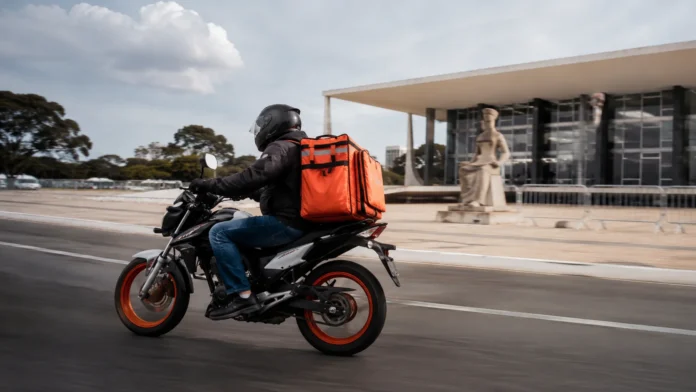 Entregador de aplicativo em motocicleta diante do STF representa julgamento sobre uberização e vínculo trabalhista