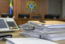 TRE-RO aplica multas em caso de assédio eleitoral em Ji-Paraná Documentos judiciais e urna desfocada representam decisão sobre assédio eleitoral em Ji-Paraná