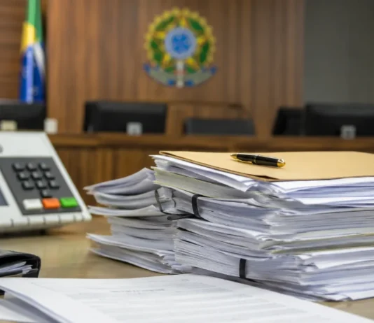 TRE-RO aplica multas em caso de assédio eleitoral em Ji-Paraná Documentos judiciais e urna desfocada representam decisão sobre assédio eleitoral em Ji-Paraná
