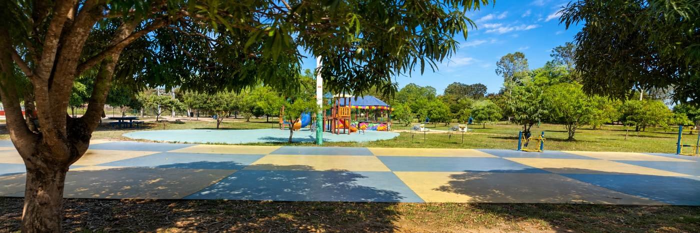 Área arborizada do Skate Parque Porto Velho com playground e piso colorido