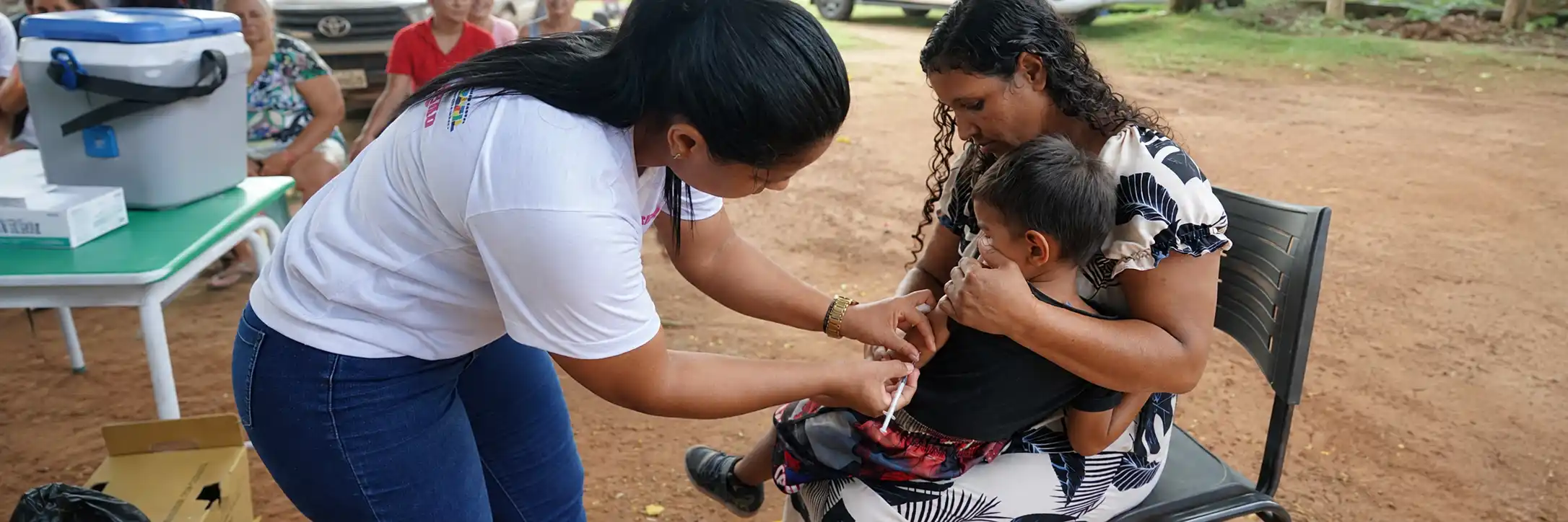 Criança recebe vacina durante a Multivacinação 2026 acompanhada pela responsável em Rondônia.