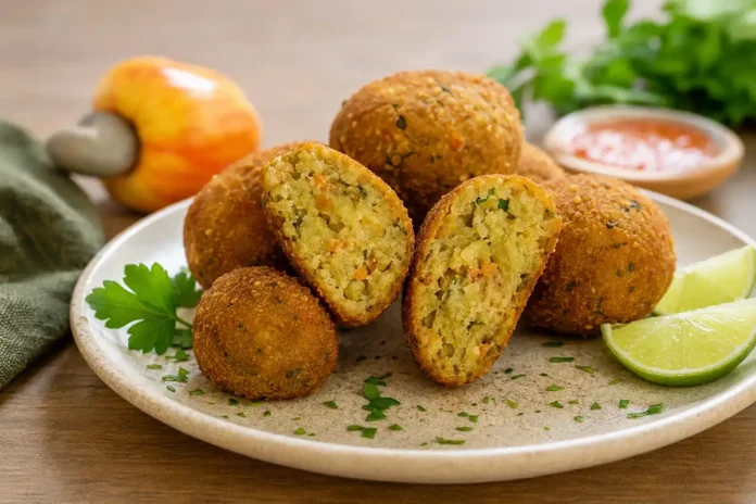 Bolinho vegetal de caju servido em prato de cerâmica com limão e ervas