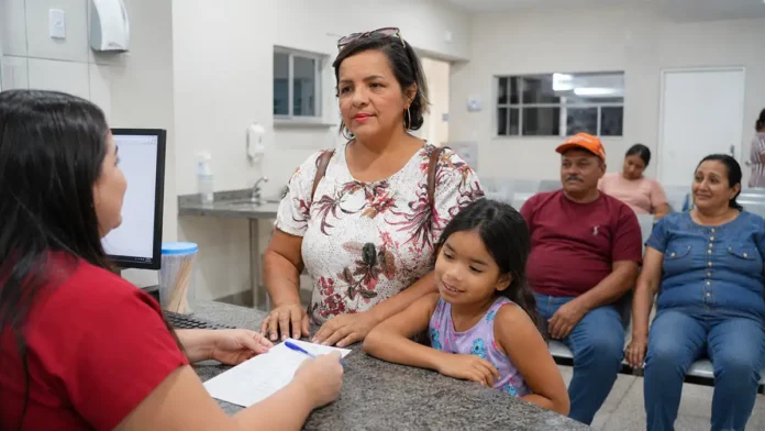 Mulher acompanhada de criança recebe atendimento noturno no Corujão da Saúde em Porto Velho.