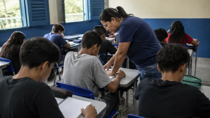 Professora orienta alunos em sala de aula durante atividade que representa o Ideb 2025 em Rondônia.