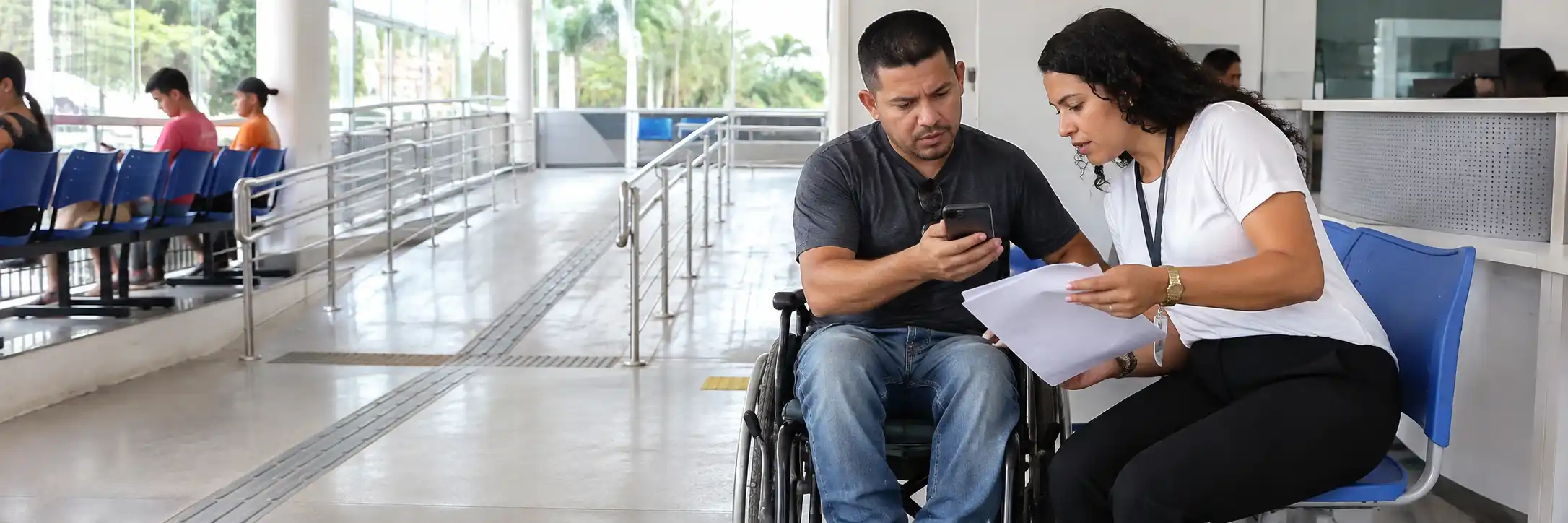 Pessoa com deficiência consulta informações do Passe Livre Digital com profissional de atendimento.