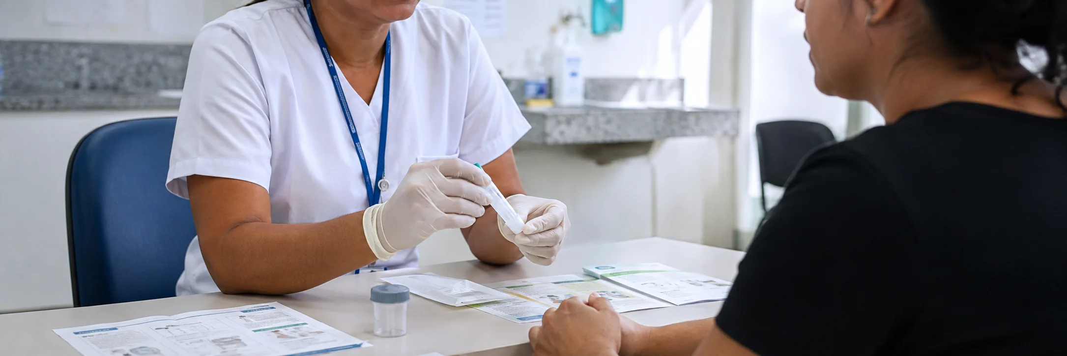 Atendimento em clínica com orientação sobre o teste FIT para rastreamento de câncer de intestino.