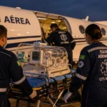 TJRO mantém condenação de plano por negar UTI aérea a bebê Equipe aeromédica prepara equipamentos de UTI aérea diante de uma aeronave para transporte médico.