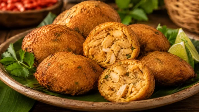 Bolinho de pirarucu seco com batata, dourado e aberto para mostrar o interior