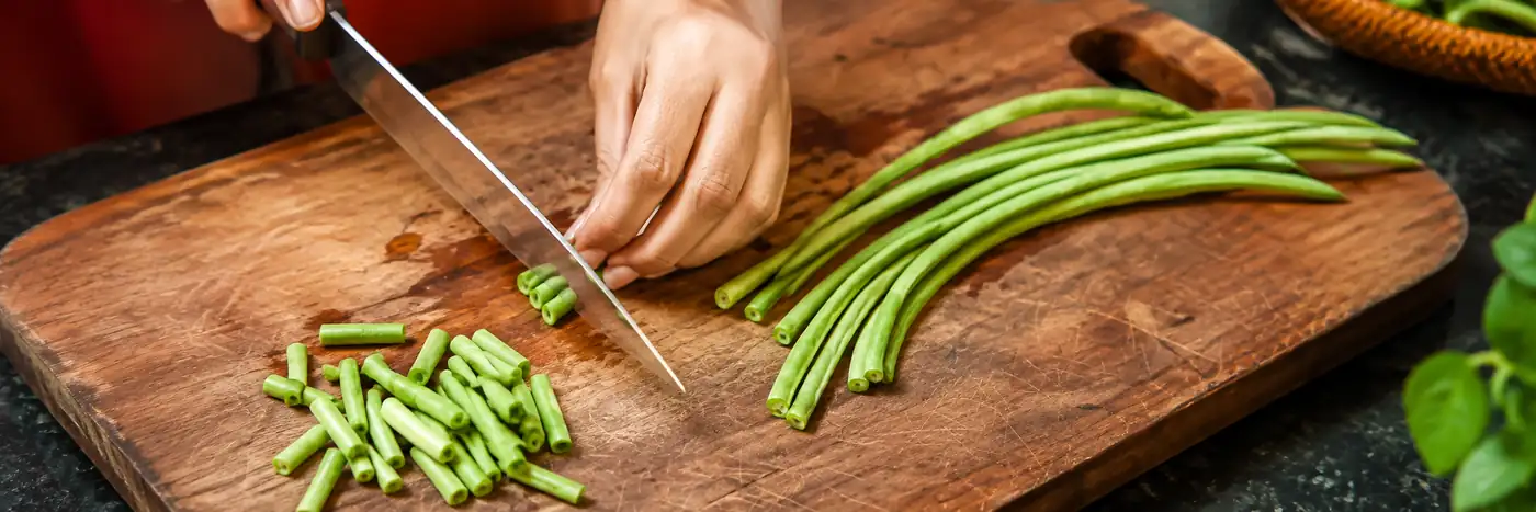 Vagem fresca sendo cortada em pedaços para os legumes salteados