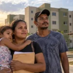 15 famílias voltam à seleção por uma moradia no Morar Melhor II Família em composição editorial humanizada diante de residencial, representando retorno de 15 famílias à seleção do Morar Melhor II em Ji-Paraná
