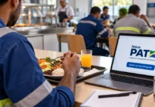 Empresas e nutricionistas do PAT têm até 9 de novembro para refazer cadastro Trabalhador em refeitório empresarial com refeição e notebook representando o recadastro do PAT