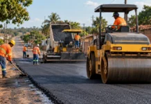 Novo Horizonte do Oeste tem 1,3 km de ruas asfaltadas e outros 1,2 km em preparação Asfalto em Novo Horizonte do Oeste ilustrado por obra urbana com trabalhadores e compactadora.