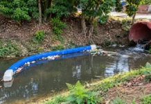Ecobarreira do Belmont recolhe quase 50 kg de resíduos na primeira limpeza Ecobarreira do Belmont em composição editorial baseada em fotos de referência, mostrando barreira flutuante azul e resíduos retidos no igarapé.