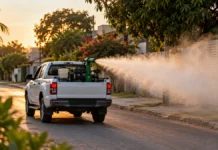 Fumacê começa por sete bairros de Vilhena; aplicação ocorre a partir das 17h Veículo de controle de endemias aplica fumacê em rua residencial ilustrando ação em Vilhena