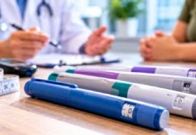 Anvisa aprova cinco novas canetas para diabetes e obesidade Canetas GLP-1 ilustrativas sobre mesa de consultório, com fita métrica e atendimento médico ao fundo.