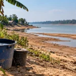 Porto Velho lança campanha contra estiagem e queimadas Estiagem em Porto Velho ilustrada por margem de rio com solo exposto e vegetação próxima a comunidade ribeirinha de Rondônia.